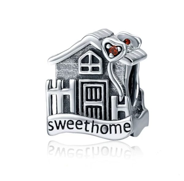 Product Afbeelding Vooraanzicht van onze prachtige bead uit de familie collectie. Dit huis gemaakt van 925 sterling zilver heeft een gravure met sweet home. Details met ramen en deuren maken dit huisje af. rechtsboven het huis zit een rood hart van zirkonia.