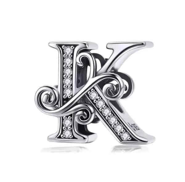 Product Afbeelding Voor en Achterzijde van onze prachtige sierlietter J uit de collectie sierletters. Deze letter k is gemaakt van 925 sterling zilver. De bead is ingelegd met zirkonia steentjes en afgewerkt met sierlijke krullen.