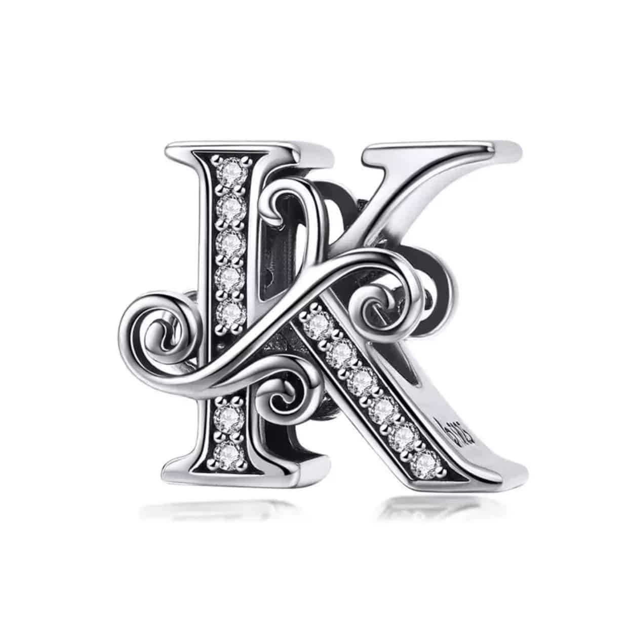 Product Afbeelding Voor en Achterzijde van onze prachtige sierlietter J uit de collectie sierletters. Deze letter k is gemaakt van 925 sterling zilver. De bead is ingelegd met zirkonia steentjes en afgewerkt met sierlijke krullen.