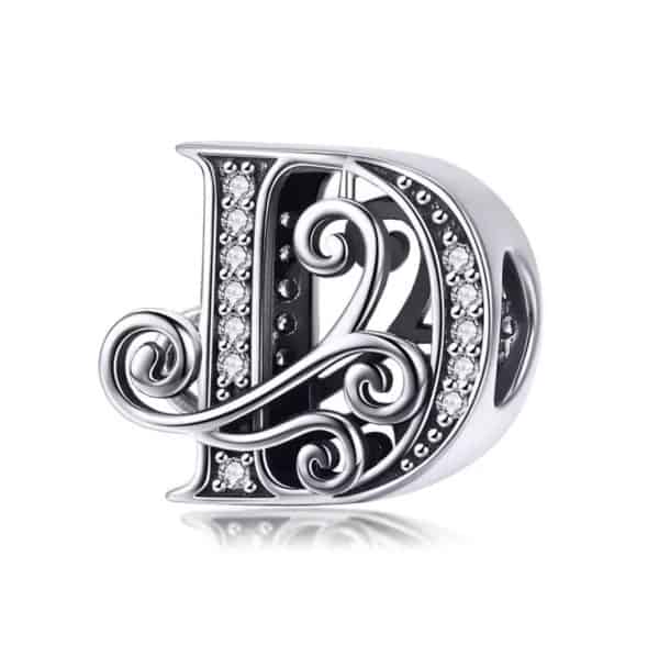 Product Afbeelding Vooraanzicht van onze prachtige letter uit de sierletters en cijfers collectie. Deze letter D bedel is gemaakt van 925 sterling zilver en is ingelegd met zirkonia steentjes. De bedel wordt afgemaakt door de versieringen langs de letter D.