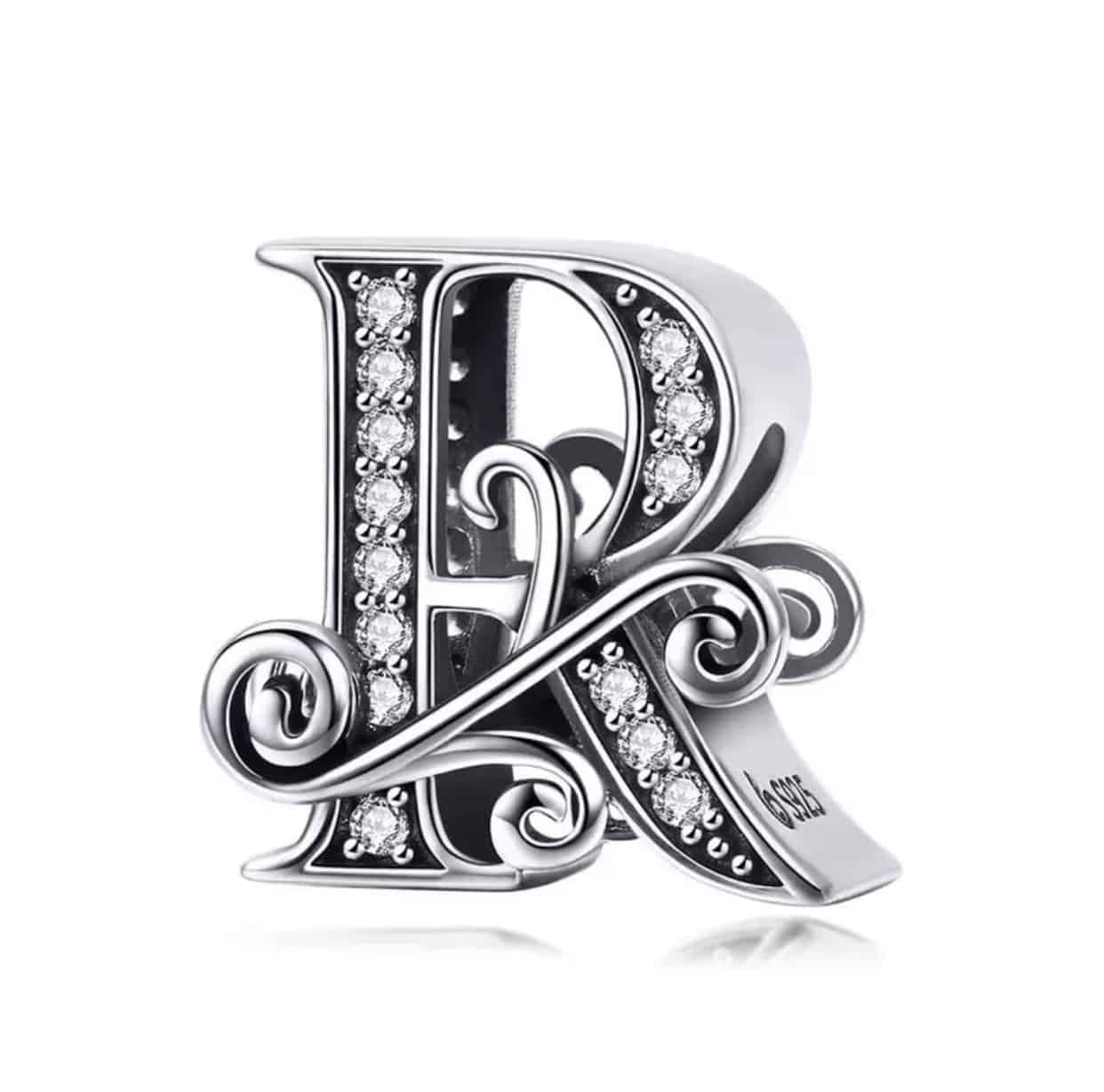 Product Afbeelding Vooraanzicht van onze mooie sierletter bead letter R. Deze prachtige sier letter r is gemaakt van 925 sterling zilver en is ingelegd met zirkonia en heeft als mooie afwerking een sierlijke krul door de letter heen.