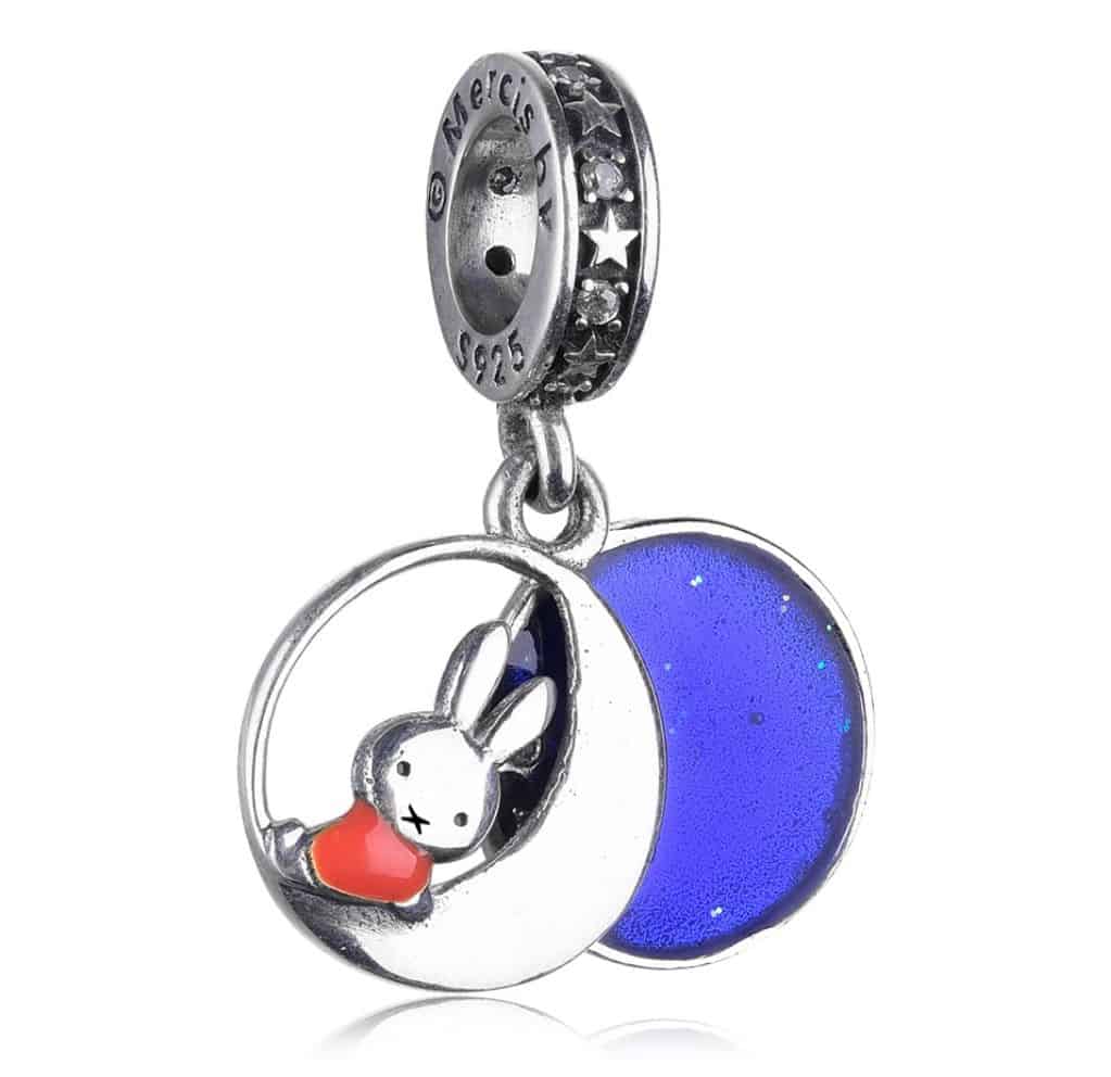 Product Afbeelding Vooraanzicht van onze prachtige nijntje met maan bedel. Deze verschrikkelijk mooie charm is gemaakt van 925 sterling zilver. De miffy charm is 2-delig. De achteste is gemaakt van blauwe emaille met sterretjes. Het voorste gedeelte is nijntje die op de maan zit met bruna rode jurk. De charm is afgewerkt met sterren. Deze sikkel bedel is lief.