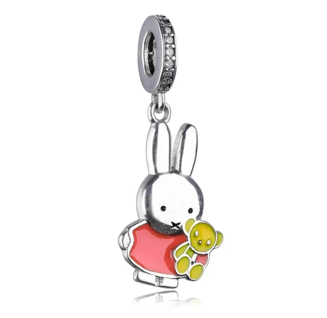 Product Afbeelding Vooraanzicht van onze prachtige nieuwe bedel van de nijntje collectie. Deze charm met nijntje die z'n beer vast houd is te schattig voor woorden. De bedel is gemaakt van 925 sterling zilver. Miffy haar jurikje is bruna rood. De beer is ook gemaakt van emaille in de kleur geel en afgemaakt met 925 sterling zilveren oogjes en neus. De charm is afgemaakt met zirkonia's rondom. Een echt lieve bedel.