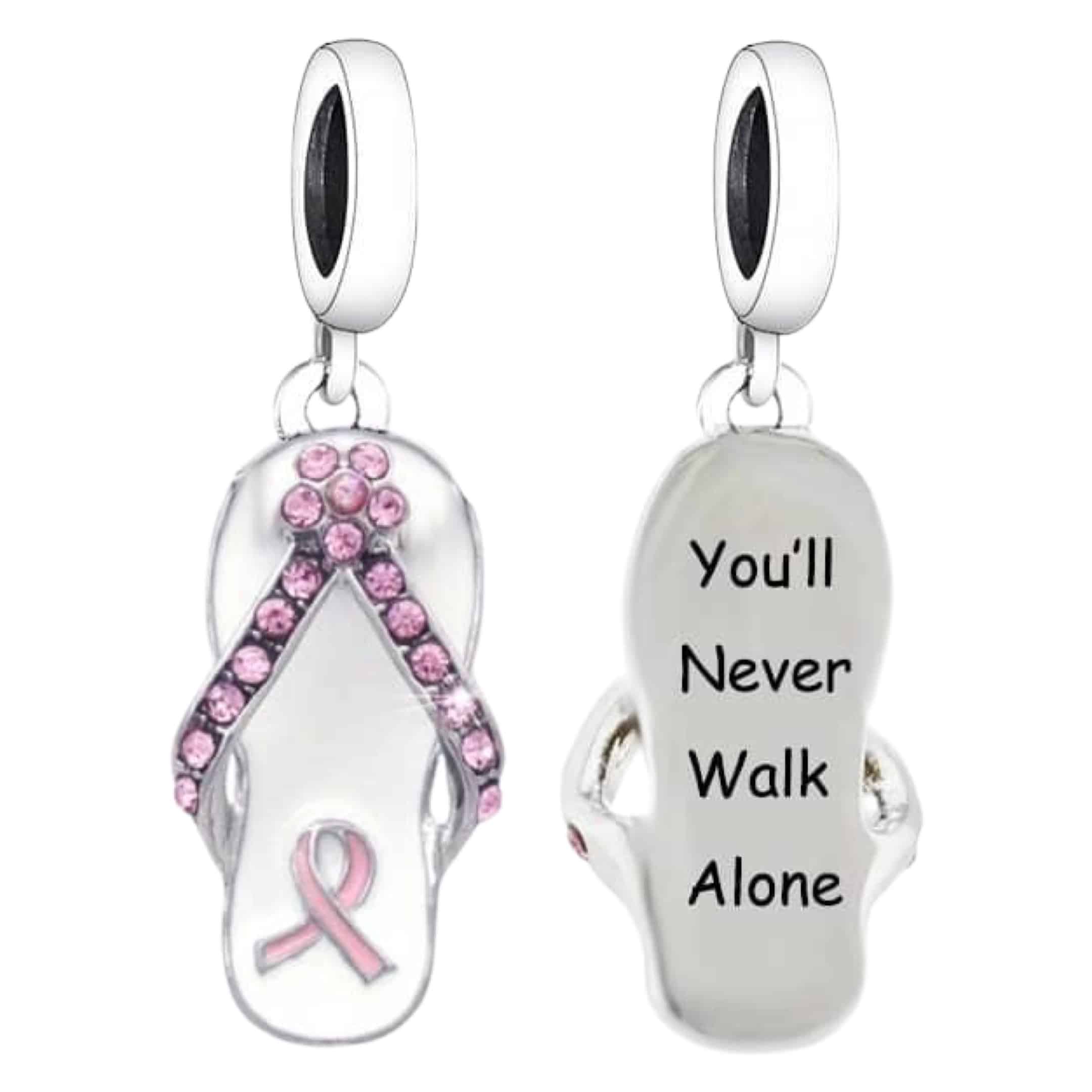 Product Afbeelding Voor en Achteraanzicht van onze nieuwe pink ribbon bedel. Deze charm heeft als teenslipper de vorm van het lintje van borstkanker ingelegd met zirkonia. Onderop de slipper zit nogmaals het teken van borst kanker met roze emaille. De charm heeft aan de onderkant de tekst you never walk alone gegraveerd in zwart en gemaakt van 925 sterling zilver.