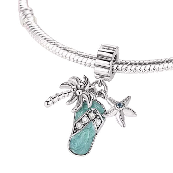 Product Afbeelding Vooraanzicht van onze nieuwe zomer collectie bedel. Een typische zomer en strand bedel. Deze 3 delige charm met slipper, palmboom en zeester. De slipper heeft emaille turquise. De palmbomen hebben cocosnoten in de boom en de zeester zit wat zirkonia. Net als de slipper is het teengedeelte met zirkonia ingelegd. Een eyecatcher voor de zomer.