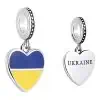 Product Afbeelding Voor en Achterzijde van onze mooie hart vlag charm oekraine. Deze reisbedel heeft blauw en geel emaille die staan voor de vlag van oekraine. Op de achterkant van het hart staat in zwart ukraine gegraveerd. Gemaakt van 925 sterling zilver.