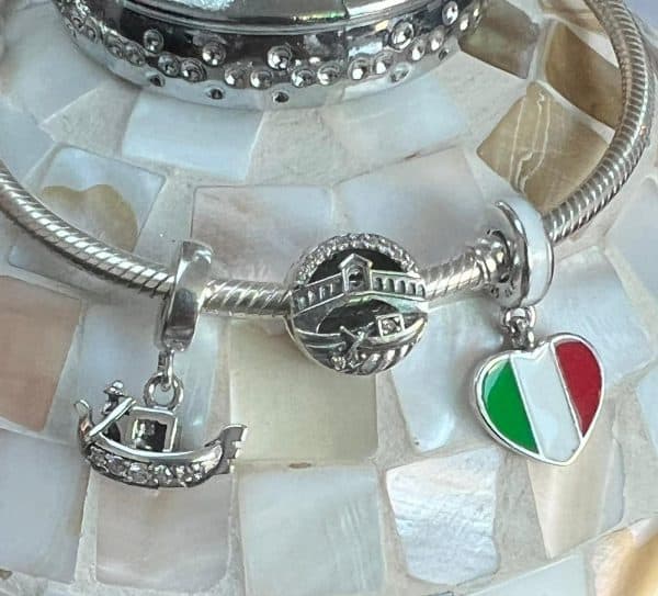 Vooraanzicht van de bedels gondel venetie, rialto brug en italiaans vlag in de vorm van een hart. Alle drie de bedels op deze foto zijn gemaakt van 925 sterling zilver.