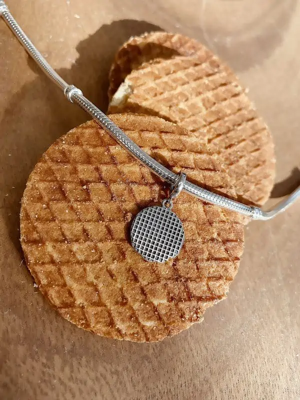 Product vooraanzicht in sfeer. Deze stroopwafel bedel uit de happy holland collectie is een echte eyecatcher. Met de druppel stroop gemaakt van emaille maakt deze bedel helemaal perfect en echte happy hollander!