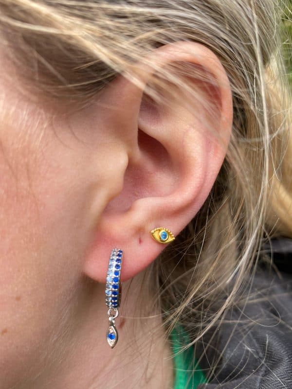 Product Afbeelding Sfeerfoto van onze super mooie oorbellen boze oog. De oorring is helemaal ingelegd met blauwe zirkonia steentjes in verschillende kleuren blauw. Gemaakt van 925 Sterling zilver.
