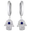 Product Afbeelding Vooraanzicht van onze prachtige hamsa oorbellen. Deze oorringen van de hand van fatima zijn gemaakt van 925 sterling zilver en totaal ingelegd met zirkonia stenen. In het midden van de hamsa hand zit een blauwe zirkonia steen.