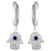 Product Afbeelding Vooraanzicht van onze prachtige hamsa oorbellen. Deze oorringen van de hand van fatima zijn gemaakt van 925 sterling zilver en totaal ingelegd met zirkonia stenen. In het midden van de hamsa hand zit een blauwe zirkonia steen.