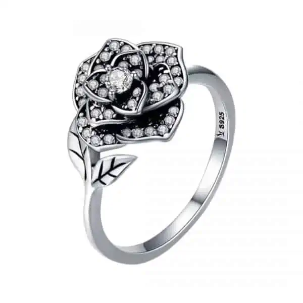 Product Afbeelding Vooraanzicht van onze nieuwe ring. Deze prachtige ring Roos met zirkonia blaadjes. De stamper van de roos draagt een grote zirkonia. Aan het uiteinde van de ring die verstelbaar is zitten twee blaadjes met gegraveerde nerven. Deze mooie ring is gemaakt van 925 sterling zilver. Binnen de ring staat een stempel van 925, zodat je zeker weet dat je ring roos van ECHT 925 sterling zilver is gemaakt.